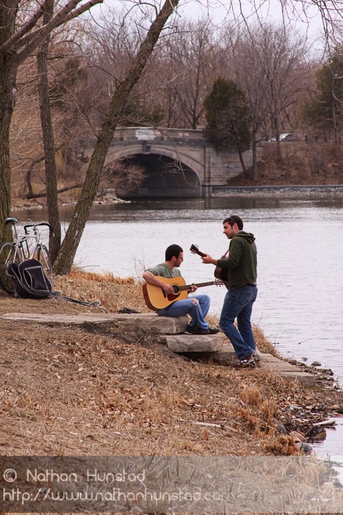 Two guitar players around Lake of the Isles.